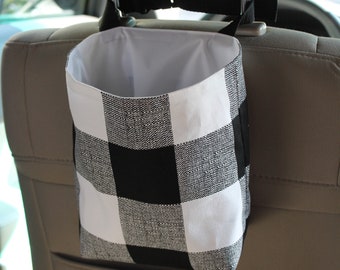 May include: Black and white checkered fabric car trash can with a strap to hang on the back of a car seat.