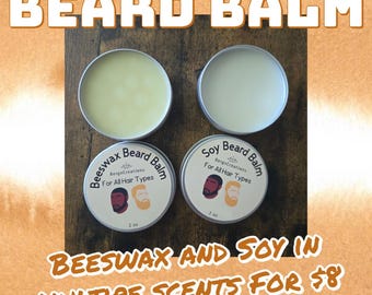 May include: Four round tins of beard balm, two open and two sealed, with the text "BEARD BALM" at the top. The bottom tins are labeled "Beeswax Beard Balm" and "Soy Beard Balm" with the text "For All Hair Types". The image also includes the text "BEESWAX AND SOY IN MULTIPE SCENTS".