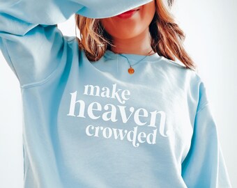 May include: Light blue sweatshirt with the text "make heaven crowded" in white lettering. The sweatshirt is size medium and is made of Chambray fabric.