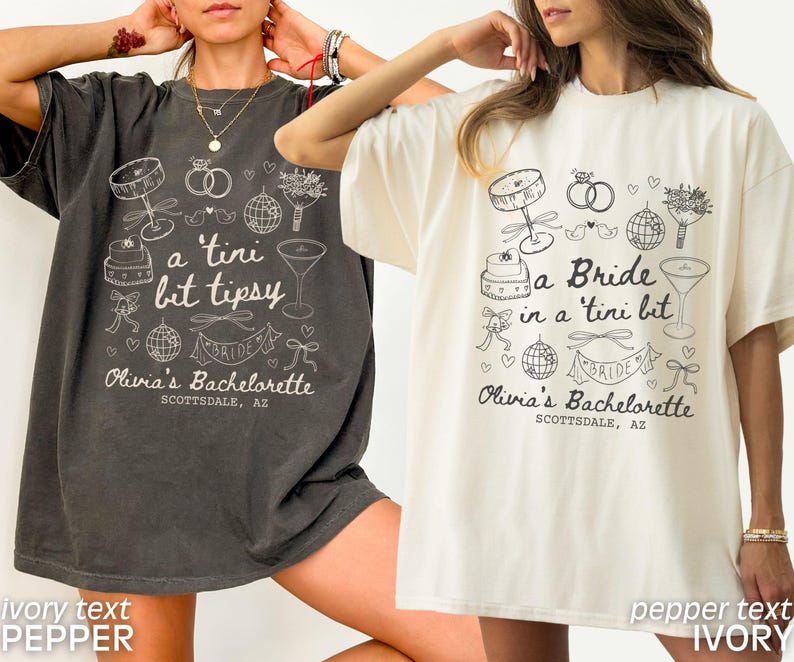 Op de afbeelding: Twee oversized t-shirts met een vrijgezellenfeestthema. De shirts bevatten een bruid, een cocktailglas, een taart en andere bruiloftgerelateerde afbeeldingen. De tekst op de shirts luidt "a tini bit tipsy" en "a Bride in a tini bit". De tekst op de shirts is in ivoor en de shirts zijn in peper en ivoor.