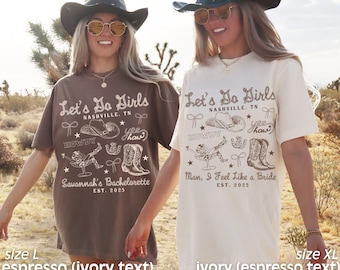 May include: Two brown t-shirts with a white design. The design features a cowboy hat, boots, and the text "Let's Do Girls Nashville, TN" and "Howdy". One shirt says "Savannah's Bachelorette Est. 2025" and the other says "Man, I Feel Like a Bride Est. 2025".