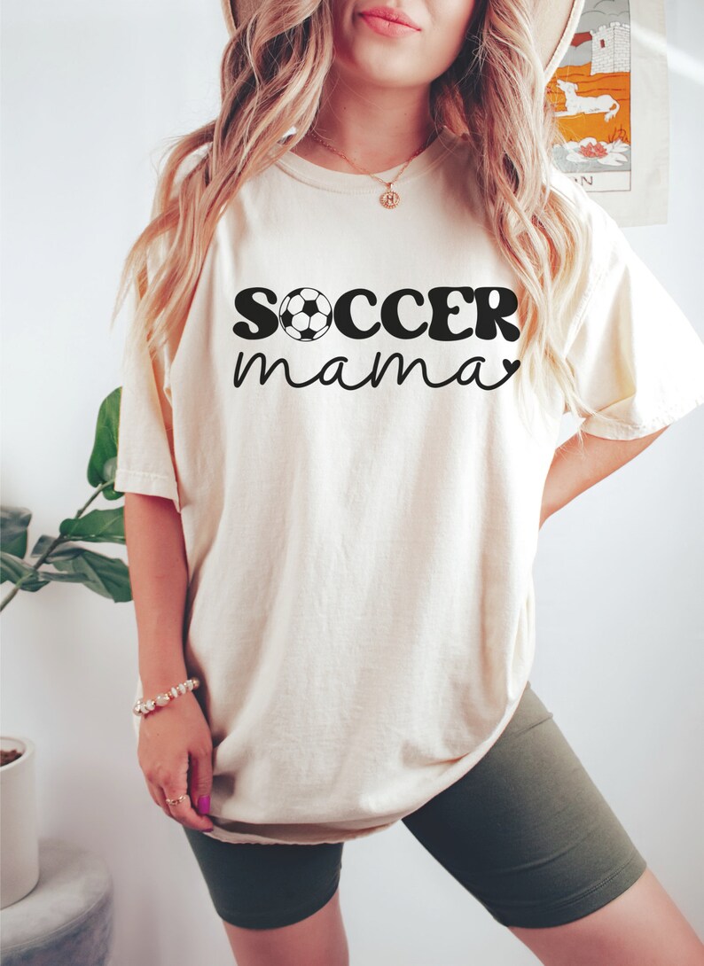 May include: A white t-shirt with the text "soccer mama" in black with a soccer ball graphic.