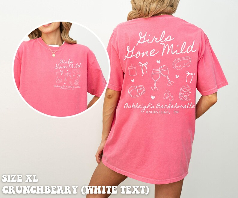 May include: A pink t-shirt with white text that says "Girls Gone Mild" and includes a design of wine glasses, a sleep mask, and other hen party themed items. The text also says "Oakleigh's Bachelorette Knoxville, TN".