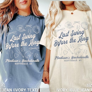May include: Two t-shirts with a baseball theme. The blue jean shirt has ivory text that reads "Last Swing Before the Ring" and "Madison's Bachelorette Scottsdale, AZ". The ivory shirt has blue jean text that reads "Last Swing Before the Ring" and "Madison's Bachelorette Scottsdale, AZ".