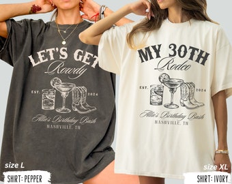 Peut inclure: Deux t-shirts avec des designs différents. Le premier t-shirt est noir avec le texte "Let's Get Rowdy" et un graphique d'une margarita et de bottes de cowboy. Le deuxième t-shirt est blanc avec le texte "My 30th Rodeo" et un graphique d'une margarita et de bottes de cowboy. Les deux t-shirts ont le texte "Allie's Birthday Bash Nashville, TN" et les années "EST. 2024".