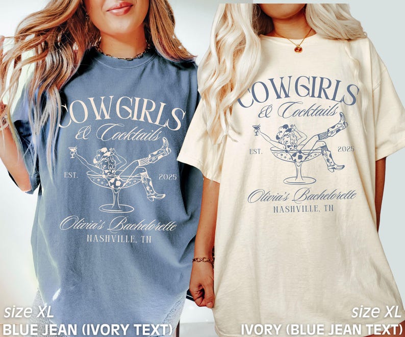 May include: Two oversized t-shirts featuring a cowgirl in a martini glass graphic and the text "Cowgirls & Cocktails" in blue. The left shirt is blue jean with ivory text. The right shirt is ivory with blue jean text. Both shirts say "Olivia's Bachelorette Nashville, TN" and "Est. 2025".