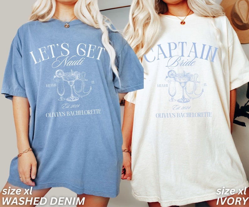 May include: Two oversized t-shirts, one in washed denim blue and the other ivory, with a bachelorette party theme. The blue shirt reads "LET'S GET Nauti" with a cocktail and anchor graphic. The ivory shirt says "CAPTAIN Bride" with a similar design. Both shirts have "Olivia's Bachelorette" and "Est. 2024".