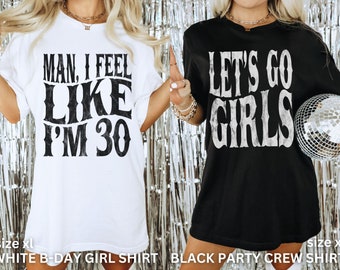 May include: Two white t-shirts with black text. The first shirt says "Man, I feel like I'm 30". The second shirt says "Let's go girls".