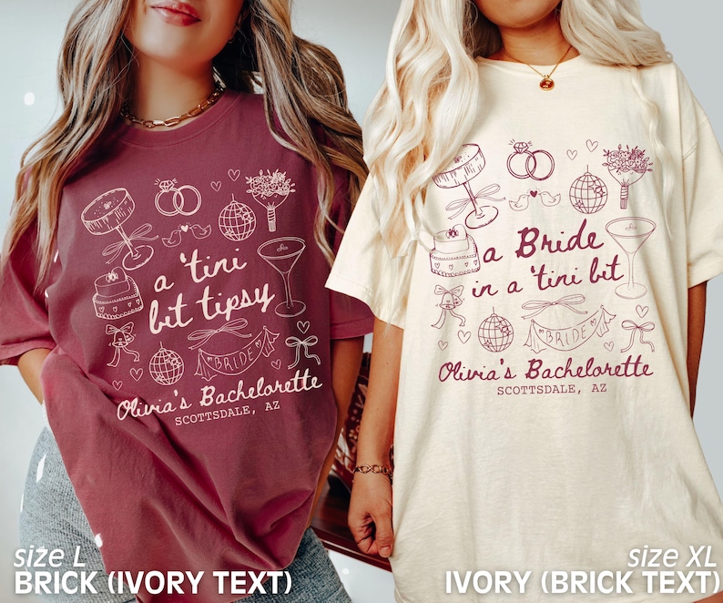 Op de afbeelding: Twee T-shirts met een thema voor een vrijgezellenfeest. Het shirt aan de linkerkant is baksteenrood met ivoorwitte tekst die "a tini bit tipsy" en "Olivia's Bachelorette Scottsdale, AZ" zegt. Het shirt aan de rechterkant is ivoorwit met baksteenrode tekst die "a Bride in a tini bit" en "Olivia's Bachelorette Scottsdale, AZ" zegt.