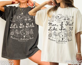 May include: Two oversized t-shirts, one dark gray and one ivory, each with a graphic design. The dark gray shirt says "Let's Go Girls" and the ivory shirt says "Man, I Feel Like I'm 30". Both shirts have a Nashville birthday bash theme.
