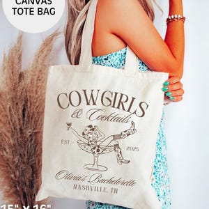 May include: A natural canvas tote bag with the text "COWGIRLS & Cocktails" printed in brown. The bag also features a graphic of a woman in a cowboy hat and boots sitting in a martini glass. The text "EST. 2025" and "Olivia's Bachelorette NASHVILLE, TN" is also printed on the bag. The bag is 15 inches by 16 inches and is made of 100% cotton.