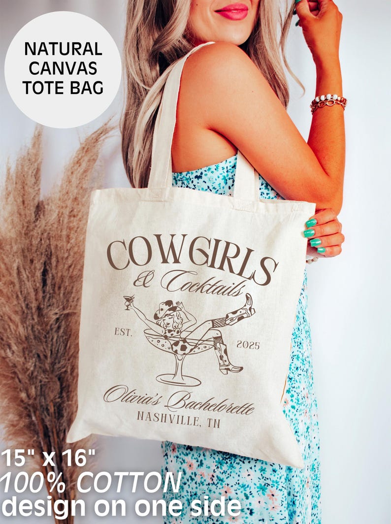 May include: A natural canvas tote bag with the text "COWGIRLS & Cocktails" printed in brown. The bag also features a graphic of a woman in a cowboy hat and boots sitting in a martini glass. The text "EST. 2025" and "Olivia's Bachelorette NASHVILLE, TN" is also printed on the bag. The bag is 15 inches by 16 inches and is made of 100% cotton.