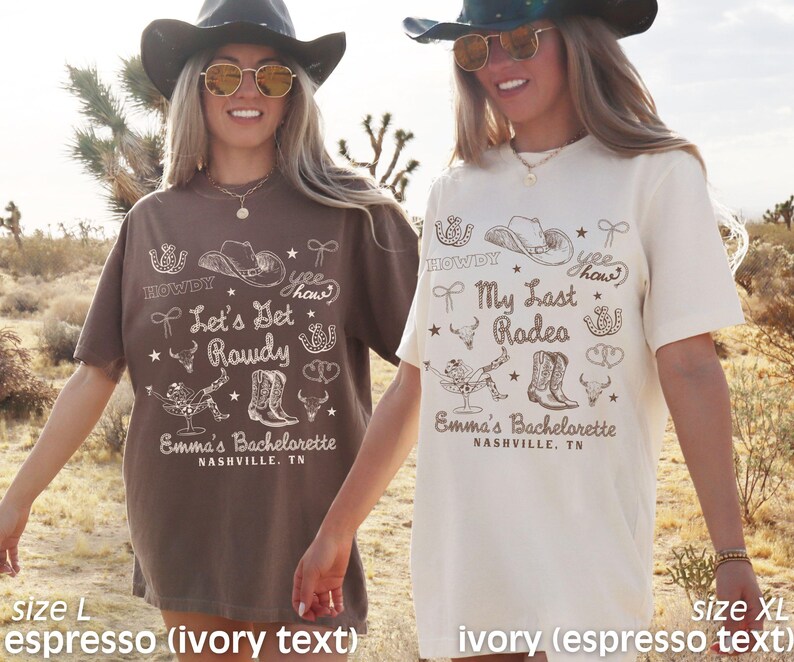 May include: Two brown and ivory t-shirts with a western theme. The shirts feature a variety of graphics, including cowboy hats, boots, and horseshoes. The text on the shirts reads "Let's Get Rowdy" and "My Last Rodeo".