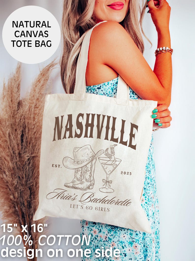 May include: Natural canvas tote bag with "Nashville" text and a cowboy hat, boots, and cocktail illustration. Features "Aria's Bachelorette" and "Let's Go Girls" text. Bag dimensions are 15" x 16" and made of 100% cotton.