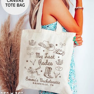 May include: A natural canvas tote bag with a brown design that says "Howdy", "My Last Rodeo", "Yee Haw", and "Emma's Bachelorette Nashville, TN". The bag is 15 inches by 16 inches and is made of 100% cotton.