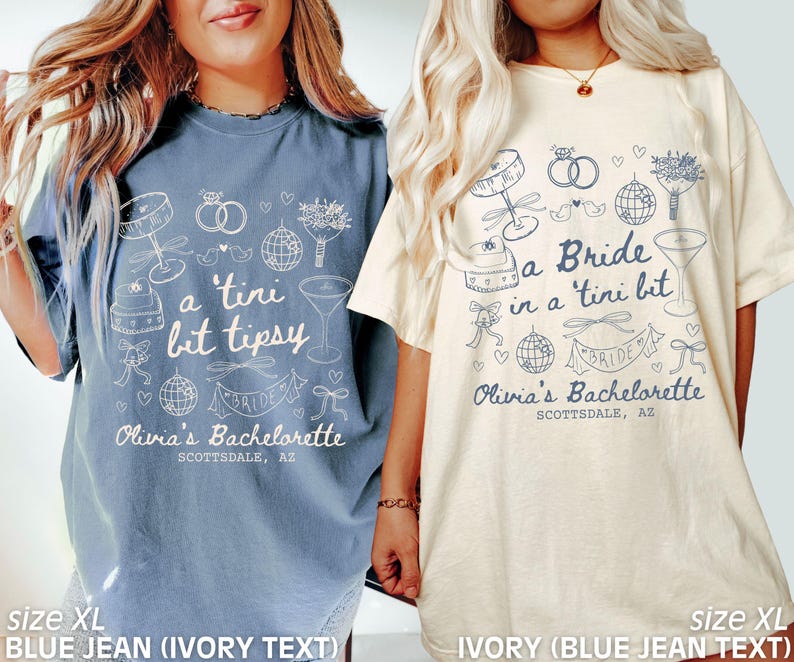 Op de afbeelding: Twee witte T-shirts met blauwe tekst en illustraties. De tekst op het linker T-shirt zegt "a 'tini bit tipsy" en de tekst op het rechter T-shirt zegt "a Bride in a 'tini bit". Beide T-shirts hebben de tekst "Olivia's Bachelorette Scottsdale, AZ".