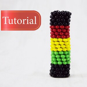 Könnte beinhalten: Nahaufnahme eines Armbands mit schwarzen, roten, gelben und grünen Perlen. Das Armband ist in einer vertikalen Säule gestapelt.