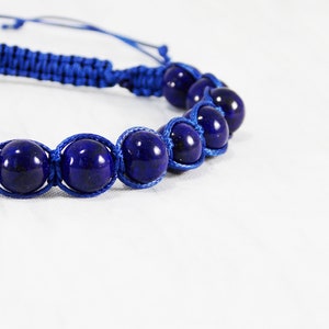 May include: A blue braided bracelet with dark blue gemstone beads.
