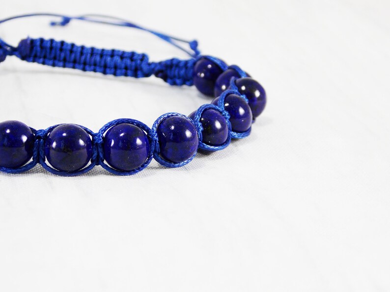May include: A blue braided bracelet with dark blue gemstone beads.
