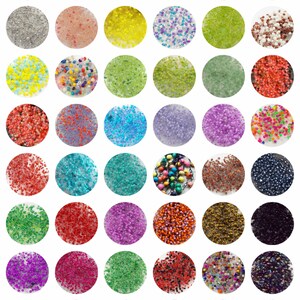 May include: Assortment of colourful seed beads in various shapes and sizes. The beads are displayed in small, round containers.