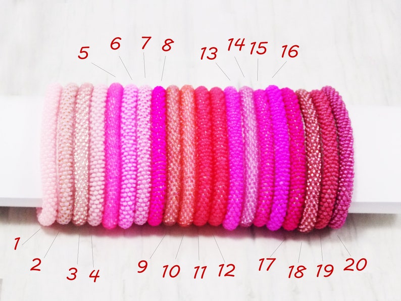 May include: Twenty pink and red beaded bracelets in various shades, numbered 1 through 20.