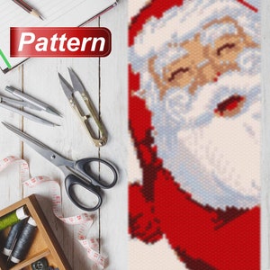 May include: A close-up of a beaded Santa Claus pattern. The pattern is made with red, white, and blue beads. The Santa Claus is smiling and has a white beard.
