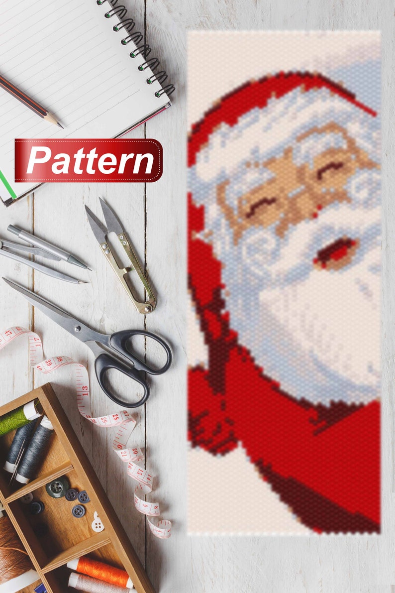 May include: A close-up of a beaded Santa Claus pattern. The pattern is made with red, white, and blue beads. The Santa Claus is smiling and has a white beard.