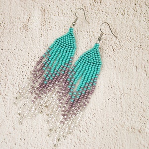 May include: A pair of long, beaded earrings with a gradient of turquoise, purple, and silver beads.