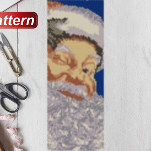 May include: A beaded pattern of Santa Claus's face with a white beard and blue background. The pattern is made with small beads and is suitable for a craft project.