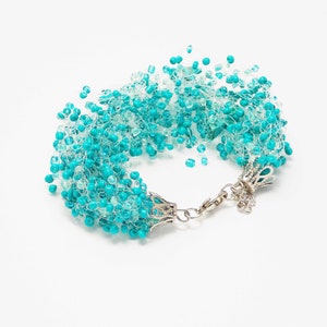 May include: A turquoise and white beaded bracelet with a silver clasp.