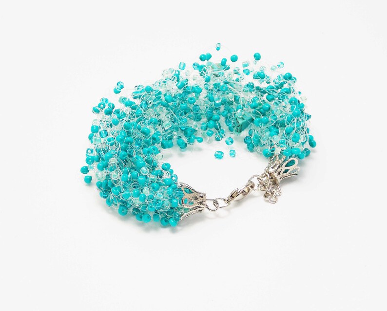 May include: A turquoise and white beaded bracelet with a silver clasp.