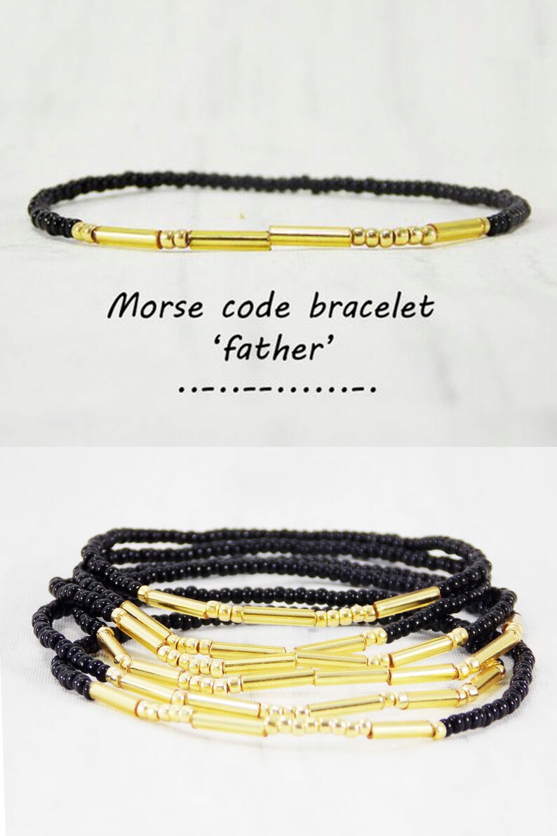 May include: A black beaded bracelet with gold bar beads spelling out the word 'father' in Morse code. The bracelet is shown layered on a white surface.