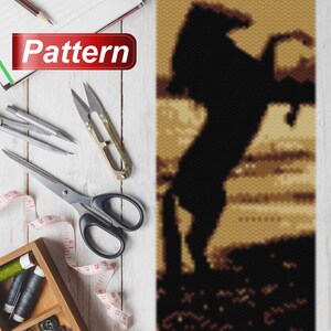 May include: A beaded pattern of a black horse rearing up on its hind legs against a beige background. The horse is silhouetted against the background.