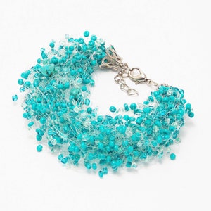May include: A turquoise beaded bracelet with a silver clasp. The beads are strung on a thin, clear thread, creating a delicate and airy look.