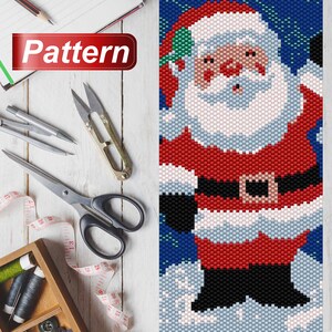 May include: A beaded pattern of Santa Claus in a red suit with a white beard and a black belt. He is standing in the snow with a blue background.