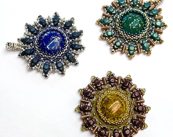 Puede incluir: Tres colgantes de sol de cuentas con cabujones de diferentes colores. Los colgantes están hechos con cuentas de plata, oro y cobre. Los cabujones son azules, verdes y amarillos.