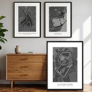 May include: Three framed wall art prints featuring grey and white maps of the Spa-Francorchamps, Monaco, and Silverstone race circuits. Each print includes the track name and Grand Prix location in black text at the bottom of the white border.