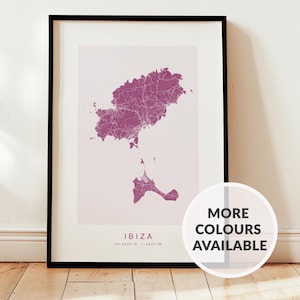 May include: A framed print featuring a map of Ibiza in purple hues, showing the island's road network. The map is set against a white backdrop, enclosed in a black frame. The print includes the word "IBIZA" and coordinates. A circular graphic says "MORE COLOURS AVAILABLE".