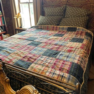 Preppy plaid patchwork quilted throw with light yellow backing.
