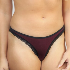 Puede incluir: Tanga de encaje color burdeos.