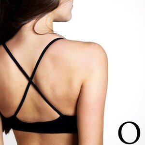 May include: A black sports bra with a criss-cross back and adjustable straps.