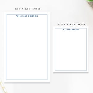 May include: Two white notepads with blue borders and the name "WILLIAM BROOKS" printed at the top. The larger notepad measures 5.5W x 8.5H inches, and the smaller one is 4.25W x 5.5H inches. Stationery.