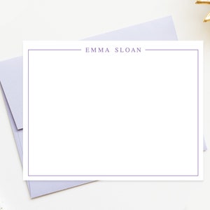 May include: A white card with a purple border and the text "EMMA SLOAN" printed in the center.