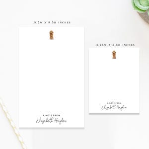 May include: Two white notepads with a small illustration of a dog at the top. The larger notepad measures 5.5 x 8.5 inches, and the smaller one is 4.25 x 5.5 inches. Each notepad has the text "A NOTE FROM Elizabeth Hayden" at the bottom.