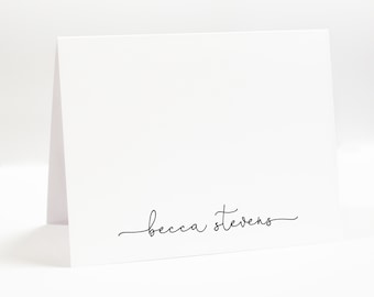 May include: A white card with the name "becca stevens" written in cursive on the bottom.
