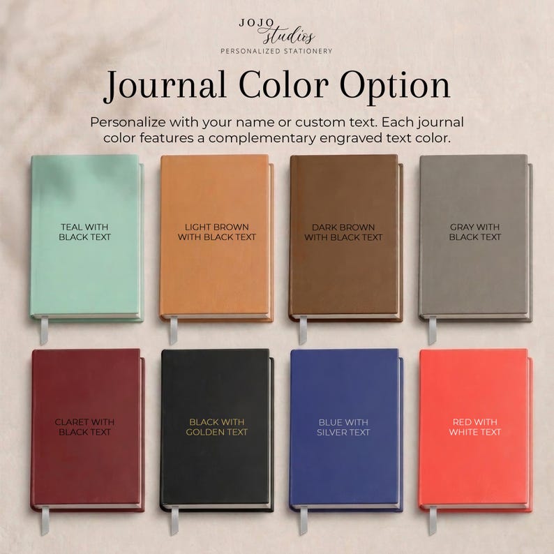 May include: Eight rectangular journals arranged in two rows, featuring colors including teal, light brown, dark brown, gray, claret, black, blue, and red. Each journal displays text indicating its specific color and the color of the engraved text.
