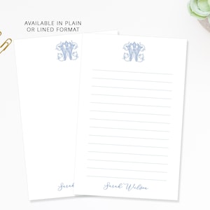 May include: White notepads with a light blue monogram and lined or plain format. The text "AVAILABLE IN PLAIN OR LINED FORMAT" is at the top. The name "Sarah Wilson" is printed at the bottom of the lined notepad.