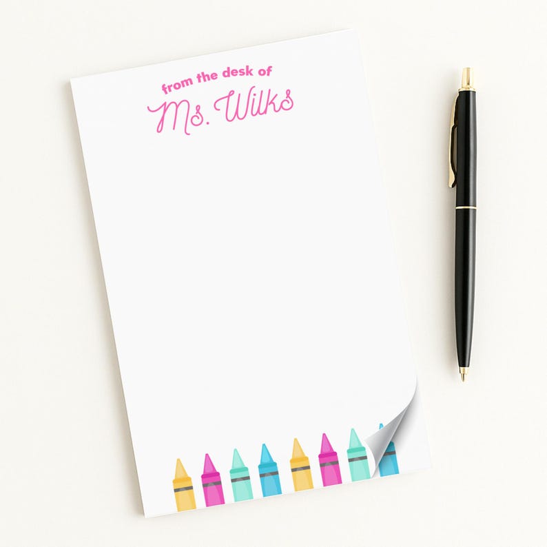 A blank sticky note with a pen next to it, both placed on a white surface.
