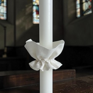 Witte linnen druppelbeschermer voor de kaarsen van de Eerste Communie.