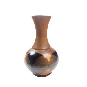 May include: A brown ceramic vase with a bulbous base and a slender neck. The vase features a pattern of overlapping shapes in shades of brown, black, and tan. The vase is approximately 8 inches tall.